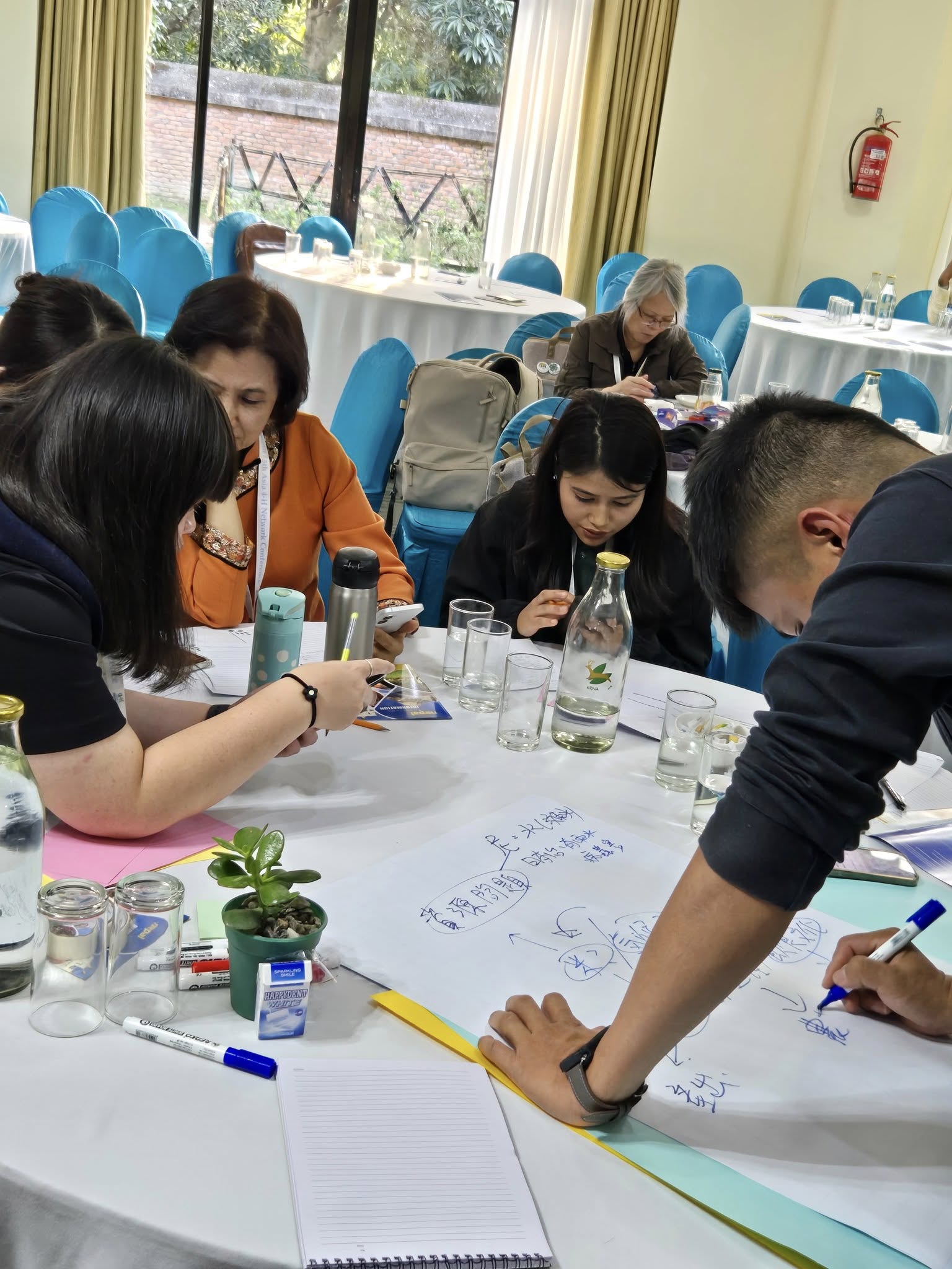 A group of people around a table working. 